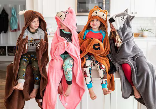 four children wearing animal themed hooded blankets