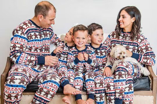 a family wearing matching gingerbread onesies